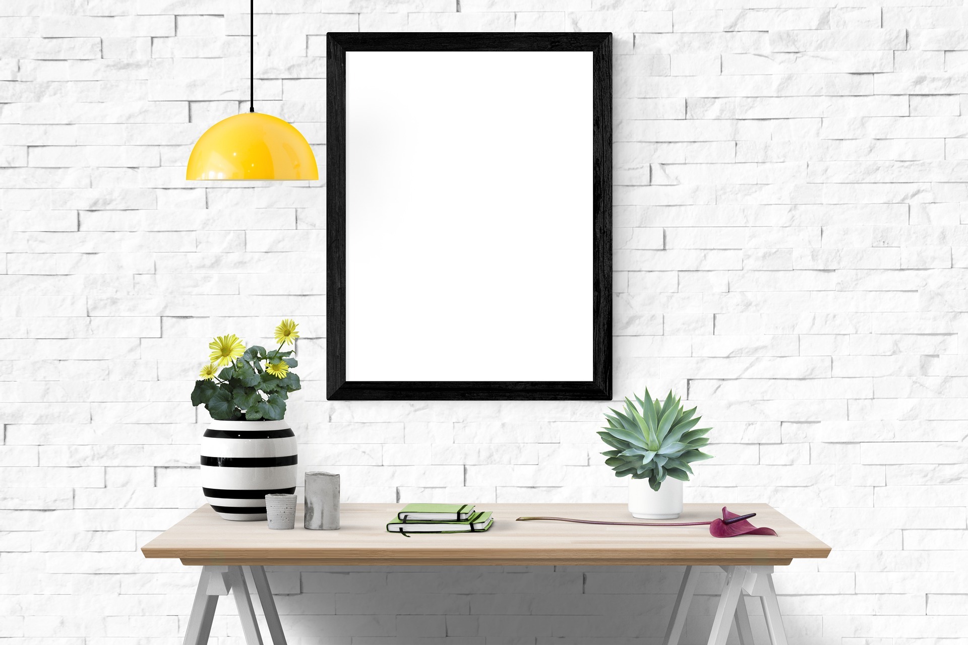 Office desk against white wall with a white canvas hanging on the wall